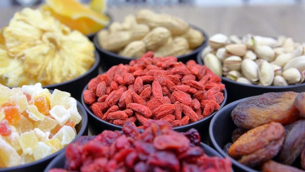 A vibrant collection of dried fruits and nuts in bowls, ideal for nutrition and healthy eating concepts.