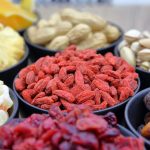 A vibrant collection of dried fruits and nuts in bowls, ideal for nutrition and healthy eating concepts.